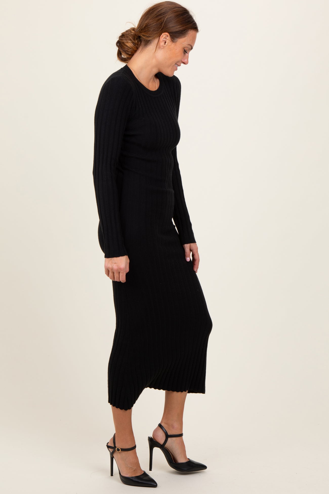 woman wearing a black ribbed knit long sleeve midi dress and black high heel shoes