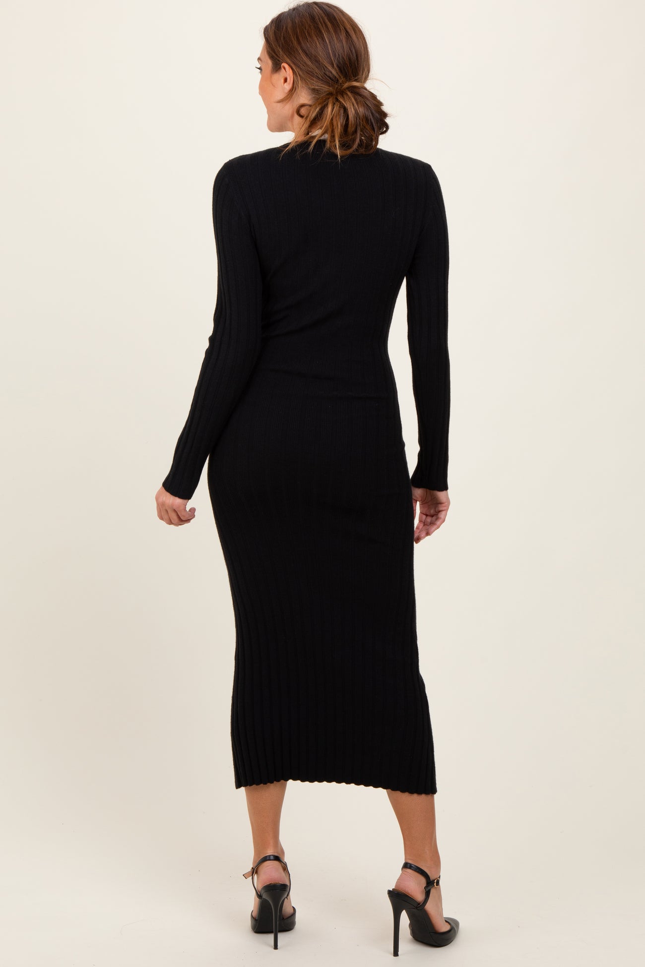 woman wearing a black ribbed knit midi dress with long sleeves, showing the back view and a fitted silhouette
