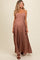 woman wearing a brown patterned maternity maxi dress with adjustable straps and a flowing silhouette, showing her baby bump