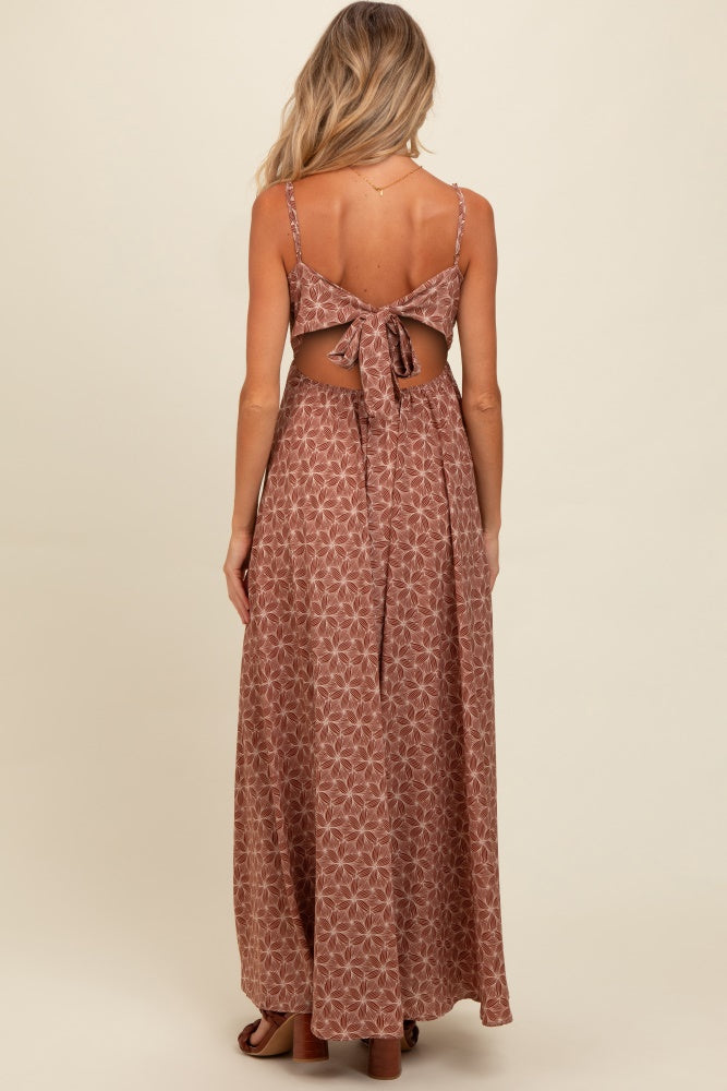 woman wearing a brown patterned maternity maxi dress with a tie-back detail and open back