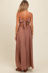 woman wearing a brown patterned maternity maxi dress with a tie-back detail and open back