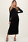 woman wearing a black ribbed maternity dress with long sleeves and a fitted silhouette, showcasing her baby bump