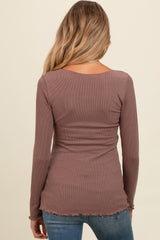 woman wearing a mauve long sleeve maternity top with a fitted style and slightly frayed hem, viewed from the back