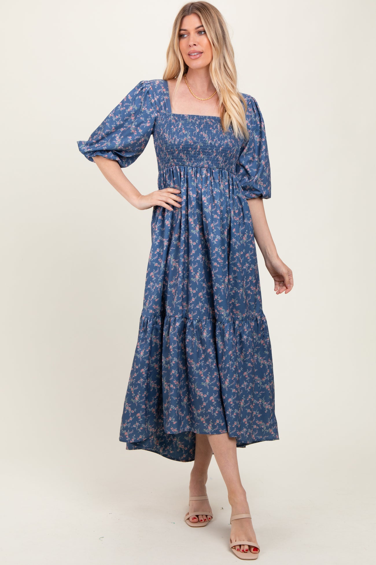 woman wearing a blue floral maxi dress with puff sleeves and a square neckline