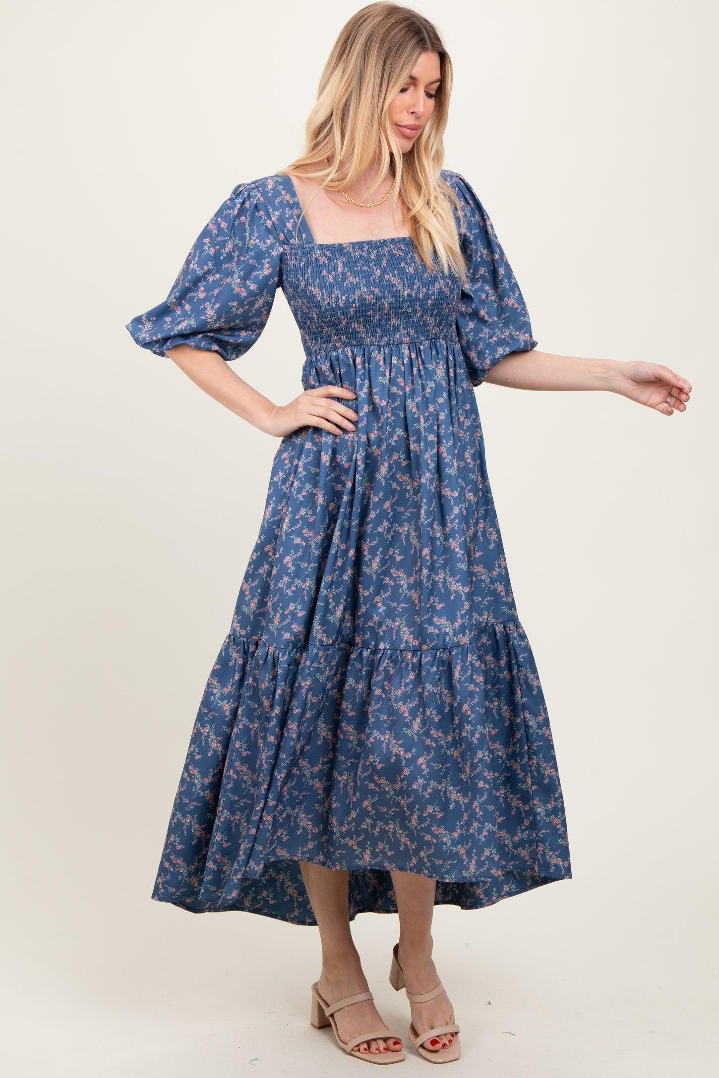 woman wearing a blue floral maxi dress with puff sleeves and a smocked bodice