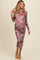 woman wearing a floral printed pink long sleeve maternity dress with a fitted silhouette and showing her baby bump