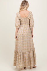 woman wearing a long yellow floral maxi dress with puff sleeves and a tiered skirt, viewed from the back