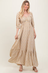 woman wearing a yellow floral maxi dress with puff sleeves and a tiered skirt