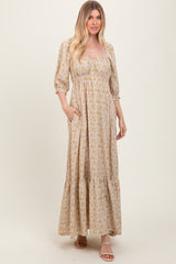 woman wearing a floral maxi dress with a square neckline and puff sleeves, features pockets and a tiered hem