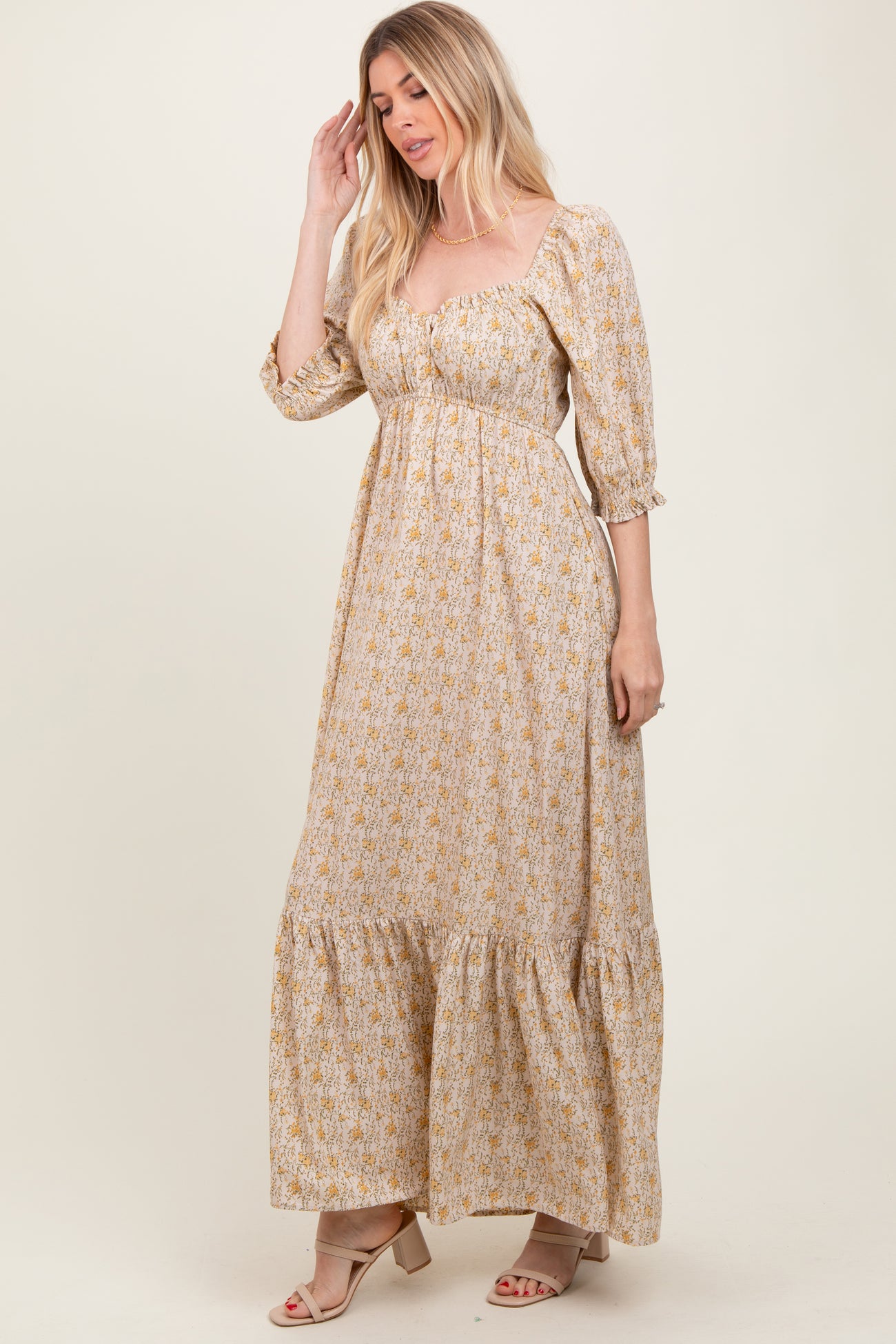 woman wearing a floral print long sleeve maxi dress with a sweetheart neckline and tiered hem
