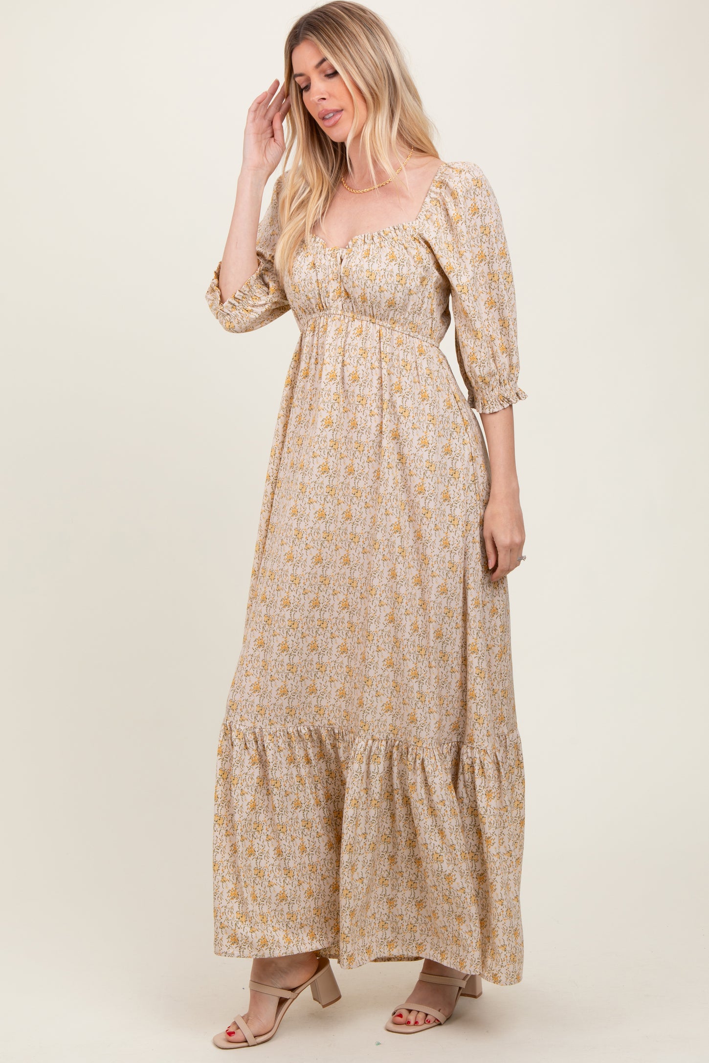 woman wearing a floral print long sleeve maxi dress with a sweetheart neckline and tiered hem