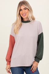 woman wearing a ribbed color block long sleeve sweater in light beige, green, and rust with a relaxed fit