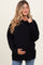 woman wearing a black maternity oversized hoodie and holding her baby bump