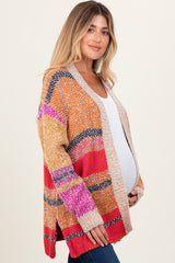 woman wearing a multicolored striped maternity cardigan and showcasing her baby bump