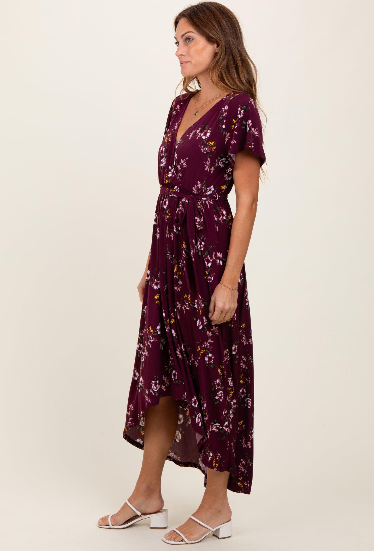 woman wearing a burgundy floral midi dress with a v-neck and short sleeves, tied at the waist