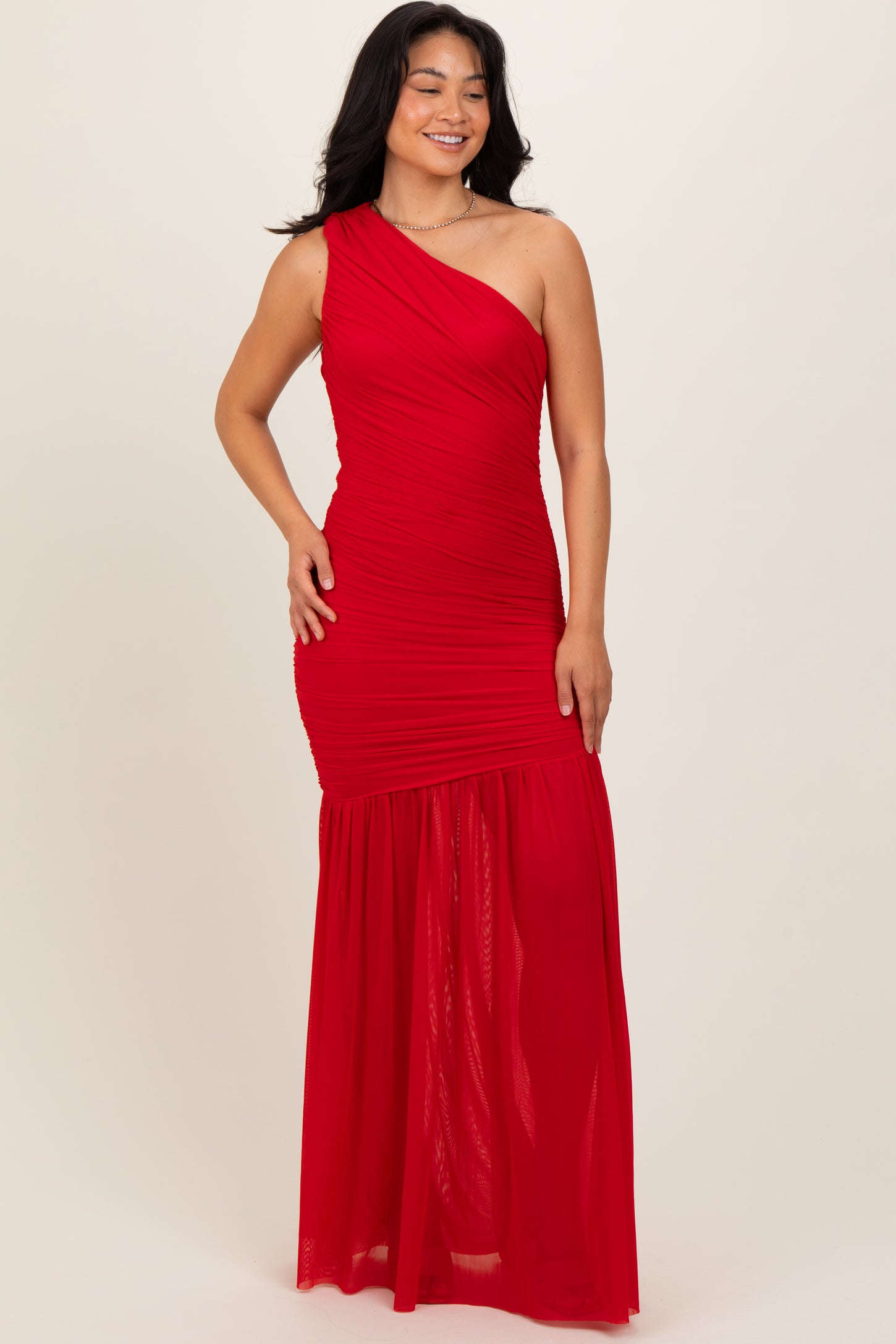 woman wearing a red one-shoulder maxi dress with ruching and a flowing skirt