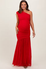 woman wearing a bright red one-shoulder maternity dress with ruched details and a flowing skirt, showing her baby bump