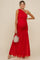 woman wearing a red one-shoulder maternity dress with ruching and flowing skirt, holding a small bag and showing her baby bump