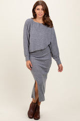 woman wearing a gray two-piece knit sweater and midi skirt set with a side slit and brown ankle boots