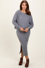 woman wearing a gray knit cropped sweater with long sleeves and matching pencil skirt with a side slit and brown ankle boots