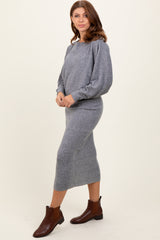 woman wearing a grey knit long sleeve midi dress and brown ankle boots