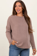 woman wearing a taupe ribbed maternity sweater with side pockets and a relaxed fit