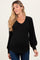 woman wearing a black ribbed maternity top with a v-neck and puff sleeves, showing her baby bump