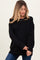 woman wearing a relaxed fit black maternity sweater with long sleeves and ribbed hem