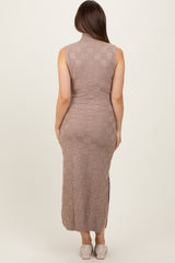woman wearing a taupe sleeveless knitted maternity dress with a mock neck and side slits