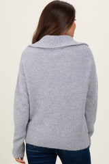 woman wearing a cozy gray maternity sweater with a fold-over collar, viewed from the back