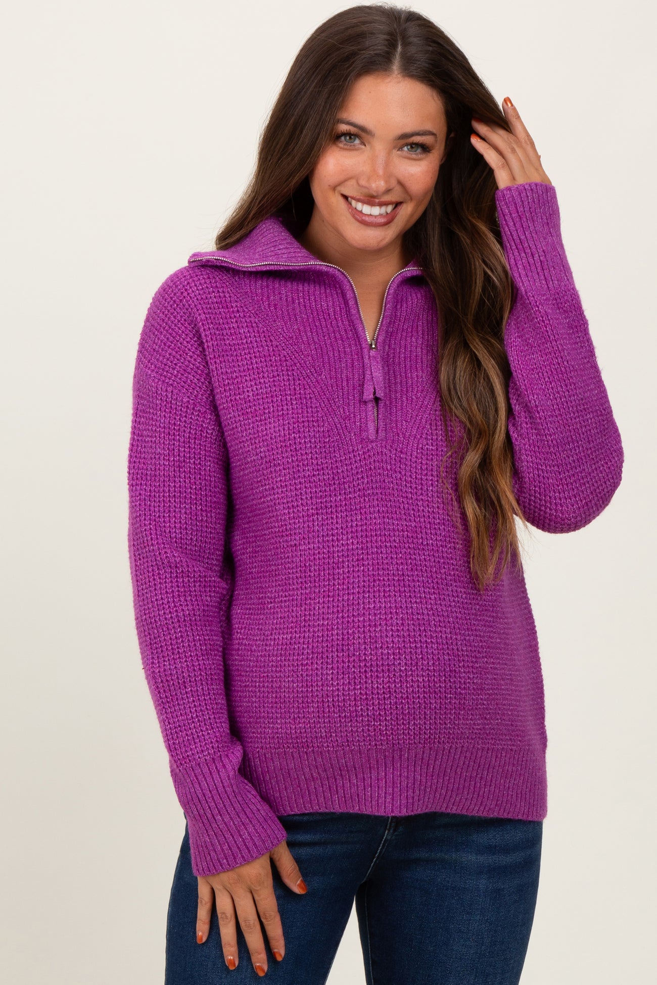 woman wearing a purple zip-up knitted maternity sweater with long sleeves and a relaxed fit