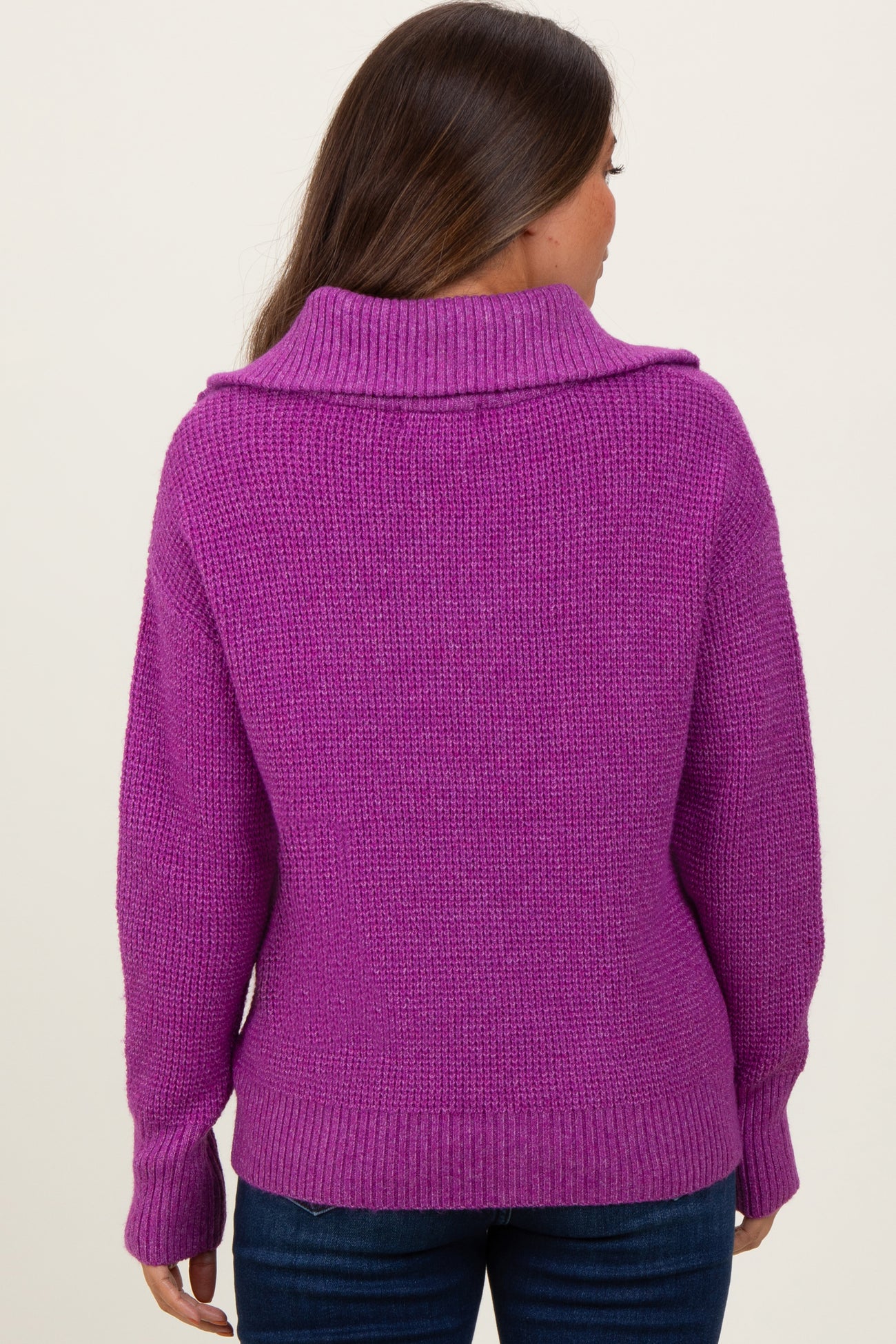 woman wearing a vibrant purple maternity sweater with a cowl neck and relaxed fit, seen from the back