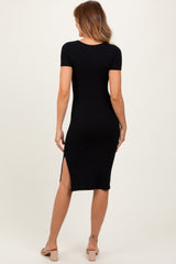 woman wearing a black ribbed midi dress with short sleeves and side slits, viewed from the back