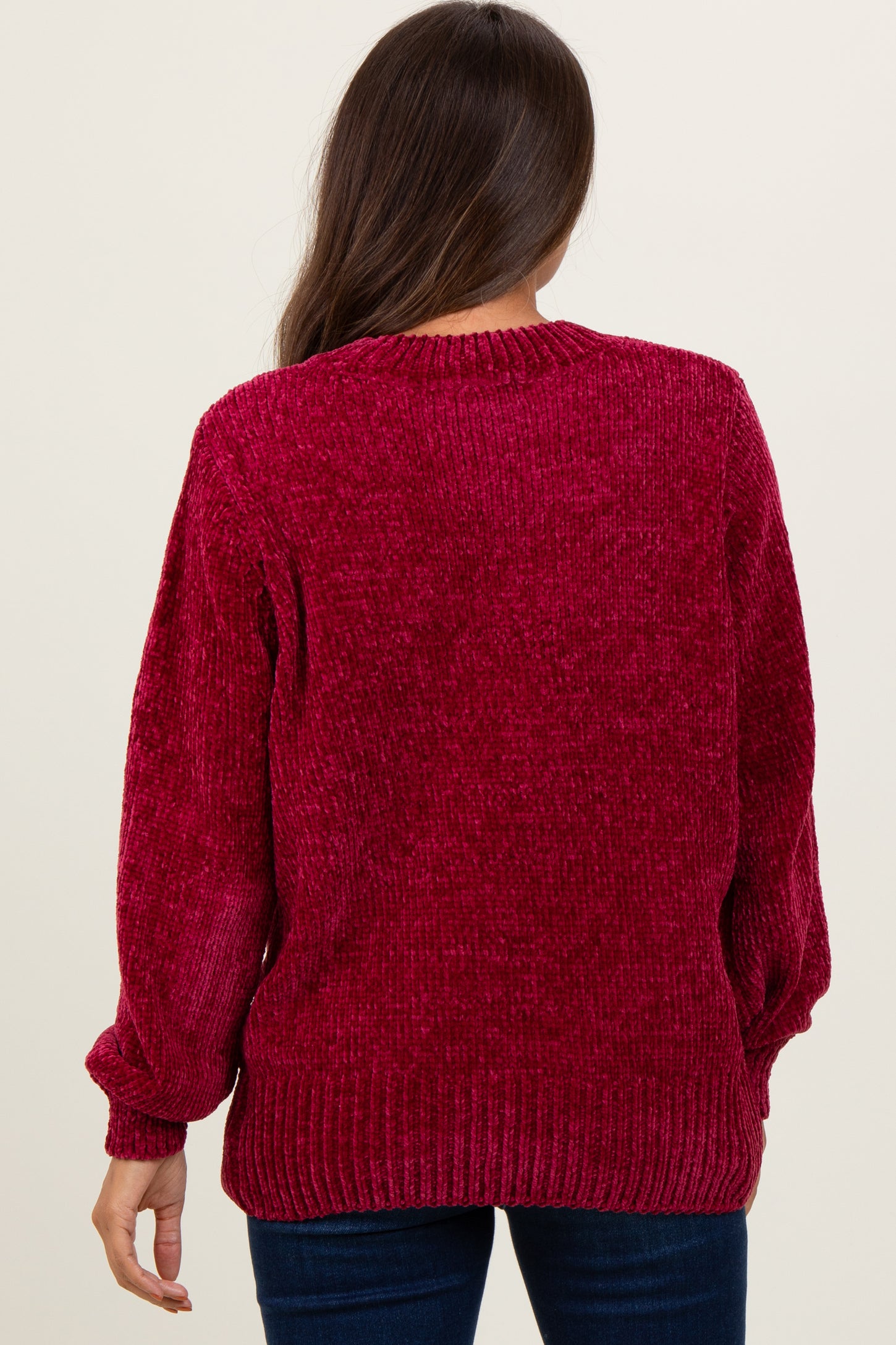 woman wearing a burgundy oversized textured maternity sweater with balloon sleeves viewed from the back