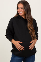 woman wearing a black maternity hoodie and holding her baby bump