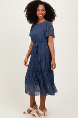 woman wearing a navy blue floral midi dress with short sleeves and a tie waist detail