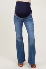 woman wearing dark blue maternity flared jeans with a supportive waistband accommodating a visible baby bump