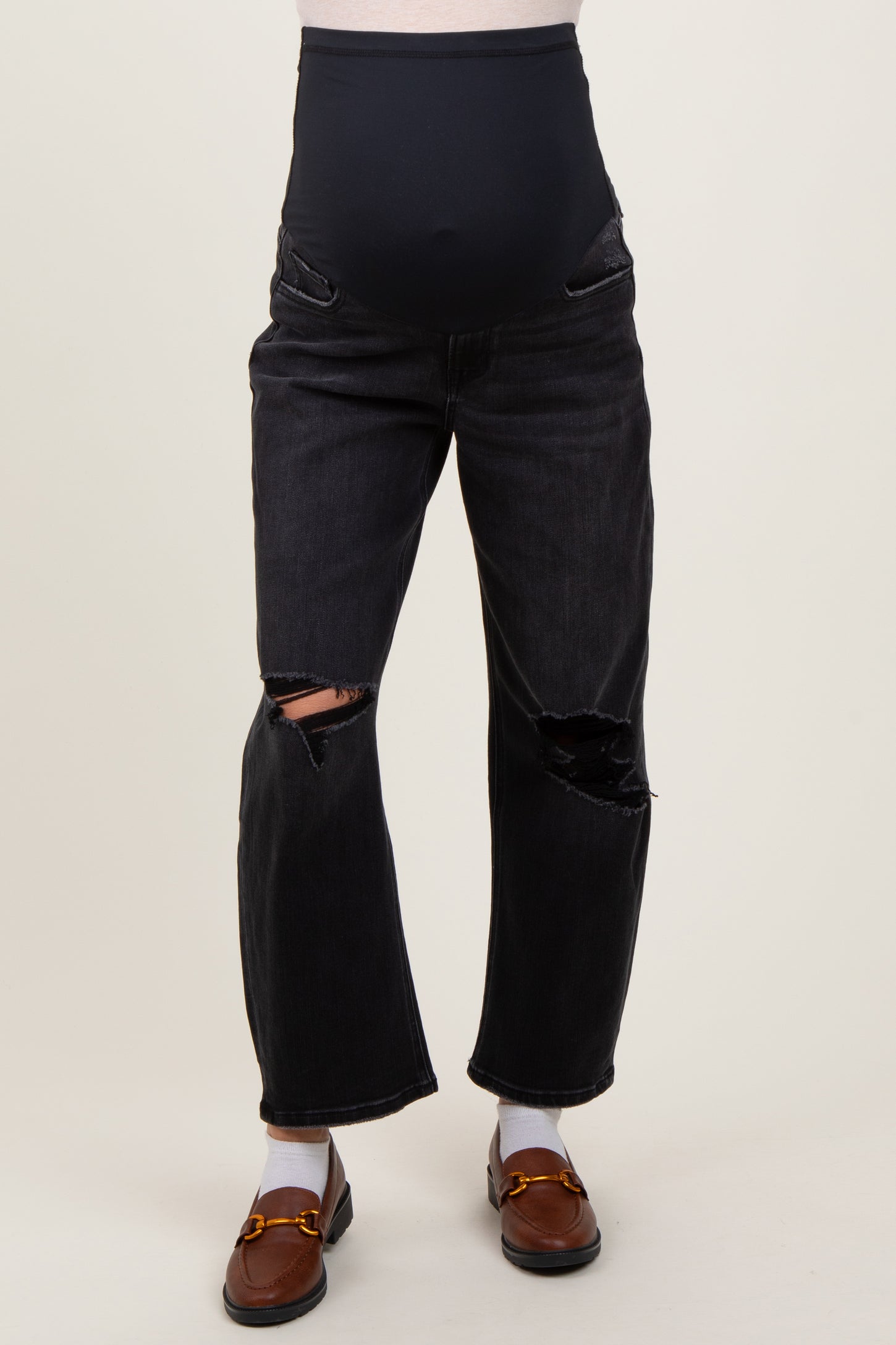 woman wearing black ripped maternity jeans with a high waistband and a visible baby bump