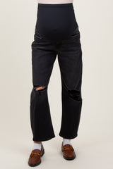 woman wearing black ripped maternity jeans with a high waistband and a visible baby bump
