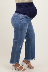 woman wearing a navy maternity tank top and distressed blue maternity jeans, showcasing a visible baby bump