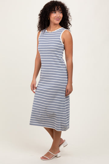 woman wearing a navy and white striped sleeveless midi dress, styled with white block-heeled sandals