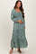 woman wearing a teal floral maternity maxi dress with smocked bodice and tiered skirt, holding her baby bump