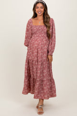 woman wearing a dusty rose floral maternity maxi dress with long sleeves and a square neckline, smiling