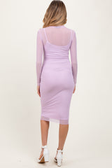 woman wearing a light purple long sleeve maternity dress with a fitted silhouette and sheer back details