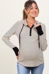 woman wearing a striped maternity hoodie with a button-up neckline and black sleeve cuffs, showing her baby bump