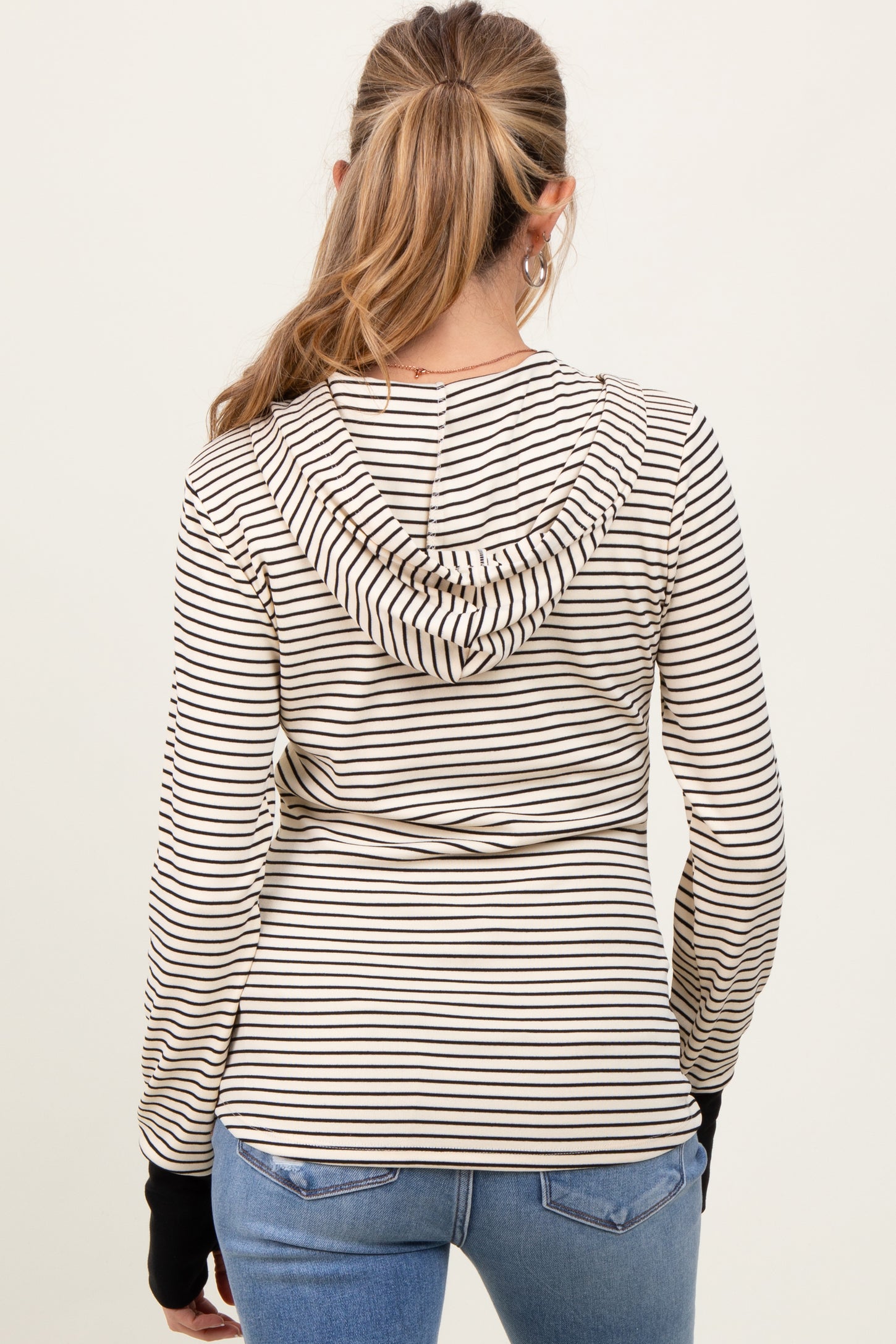 woman wearing a striped maternity hoodie with a back view, featuring a hood and long sleeves