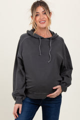 woman wearing a dark gray maternity hoodie with a relaxed fit and a visible baby bump