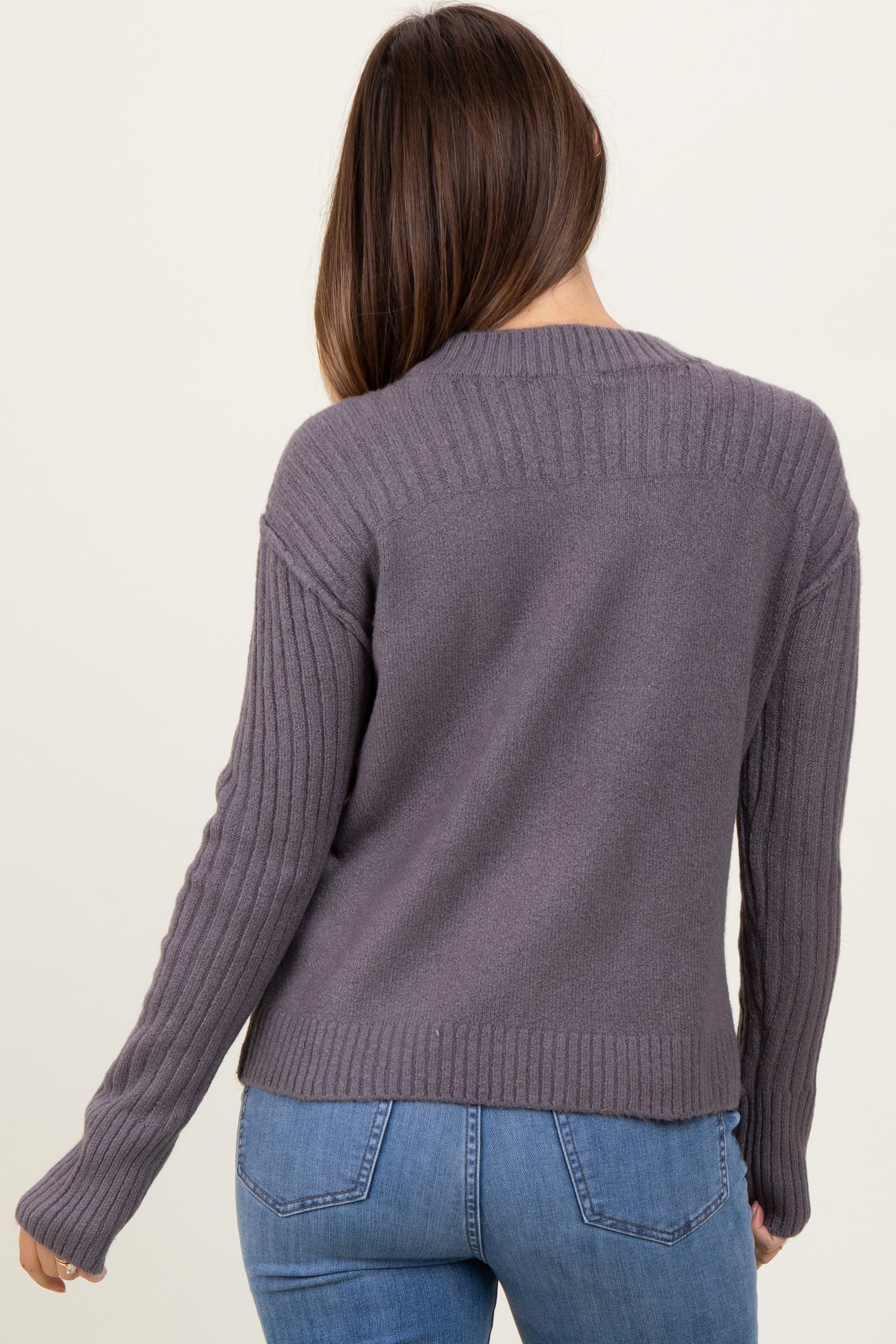 woman wearing a grey maternity sweater with ribbed detailing and a relaxed fit, showing her back