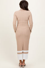 woman wearing a beige ribbed maternity dress with long sleeves and a white striped hem, shown from the back