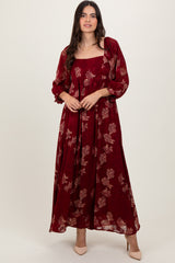 woman wearing a burgundy floral maxi dress with long sleeves and a square neckline